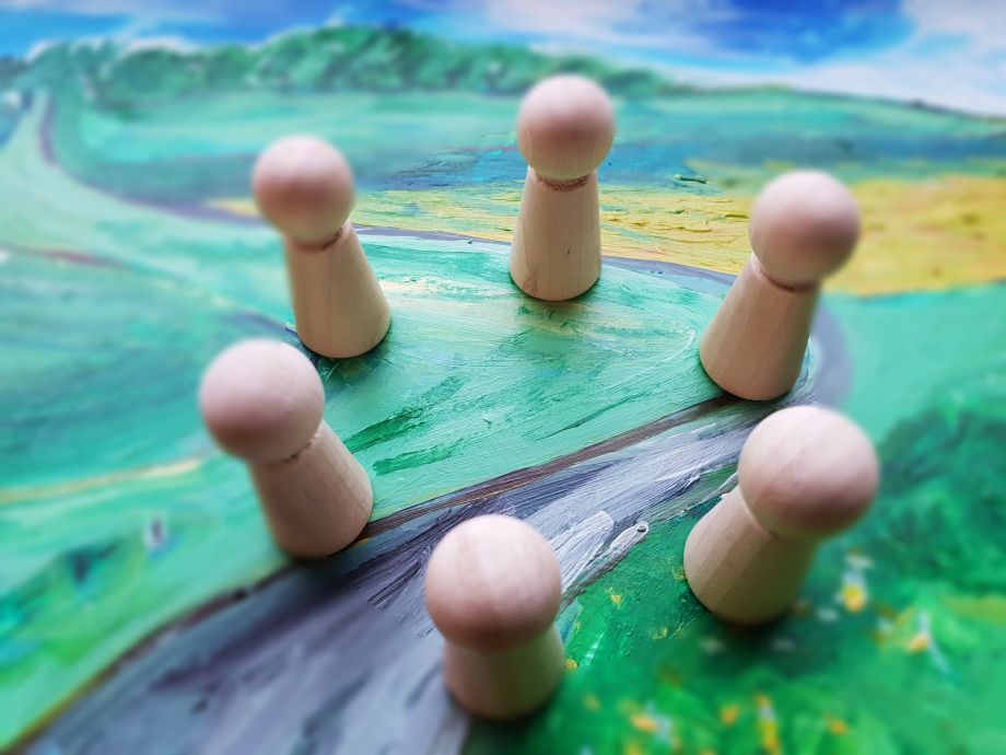 Sechs Holzfiguren im Kreis – Symbol für systemische Arbeit